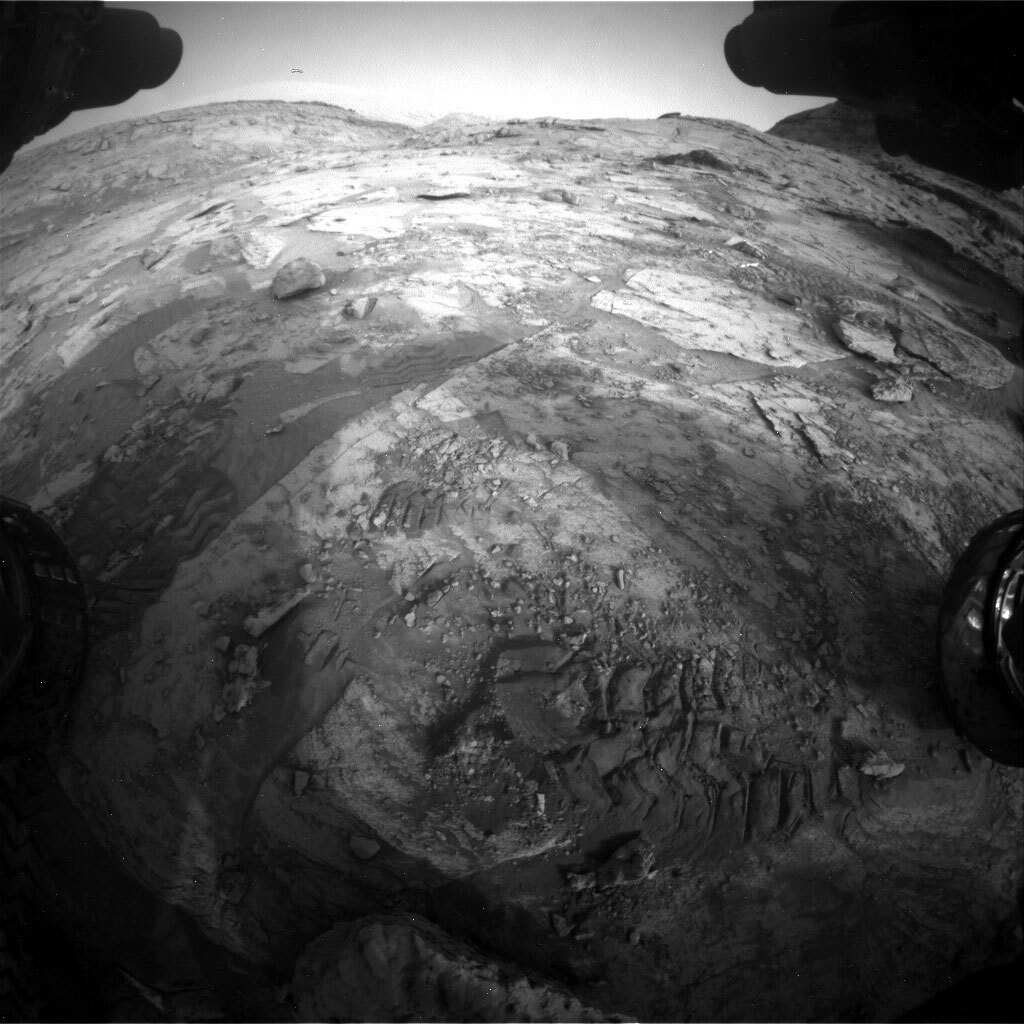 Front Haz camera image, showing churned up sand and broken rock fragments in the workspace. 