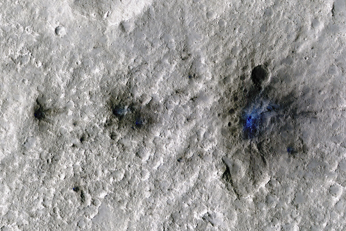 These craters were formed by a Sept. 5, 2021, meteoroid impact on Mars, the first to be detected by NASA’s InSight. Taken by NASA’s Mars Reconnaissance Orbiter, this enhanced-color image highlights the dust and soil disturbed by the impact in blue in order to make details more visible to the human eye.