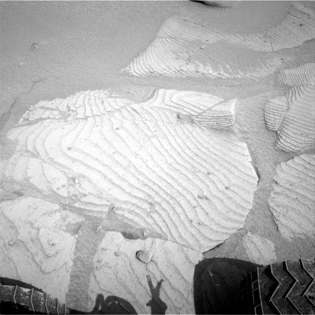 This image shows laminated bedrock near the wheels of the Curiosity rover on Mars.