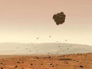 Protected by large airbags, the lander falls away from the parachute, landing safely on Mars.