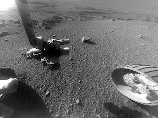 rover wheel and robot arm over rocky ground