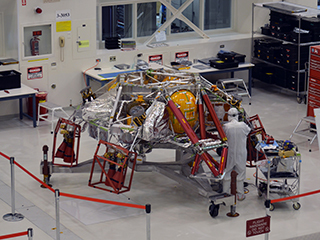 A technician working on the descent stage for NASA’s Mars 2020 mission inside JPL’s Spacecraft Assembly Facility.