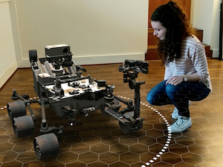 woman kneeling by augmented-reality rover