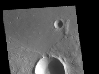 This image from NASA's Mars Odyssey shows a crater from a double impact - two meteors hitting simultaneously. The two meteors would have started as a single object and, at some point prior to impact, separated into two parts.