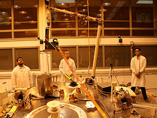 An engineering version of the robotic arm on NASA’s InSight mission lifts the engineering version of the Heat Flow and Physical Properties Probe (HP3) at NASA’s Jet Propulsion Laboratory. 