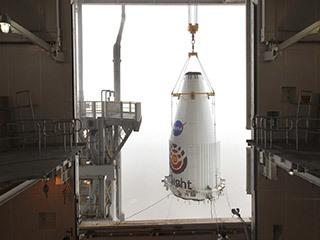 The payload fairing of the Atlas V rocket that would launch NASA's InSight lander to Mars is lifted up so that it can be mated to the top of the rocket.