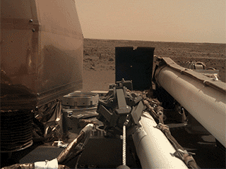 As visible in this two-frame set of images, NASA’s InSight spacecraft unlatched its robotic arm on Nov. 27, 2018, the day after it landed on Mars. 