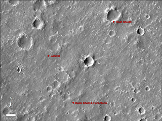 An annotated image of the surface of Mars, taken by the HiRISE camera on NASA's Mars Reconnaissance Orbiter (MRO) on May 30, 2014. The annotations — added after InSight landed on Nov. 26, 2018 — display the locations of NASA's InSight lander, its heat shield and parachute.