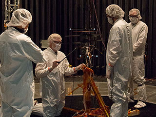 Members of NASA’s Mars Helicopter team prepare the flight model for a test in the Space Simulator,