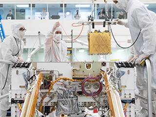 Mars 2020 engineers install the Mars Oxygen In-Situ Resource Utilization Experiment (MOXIE) into the chassis of the rover.