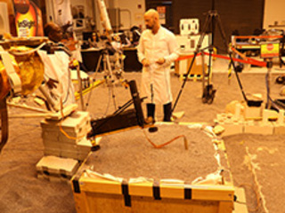 Engineers in a Mars-like test area at NASA's Jet Propulsion Laboratory try possible strategies to aid the Heat Flow and Physical Properties Package (HP3) on NASA's InSight lander, using engineering models of the lander, robotic arm and instrument. 