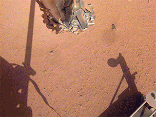 The robotic arm on NASA's Mars InSight lander moves in place over the Heat Flow and Physical Properties Package (HP3) and opens the fingers of its grapple in this series of images from June 1, 2019.