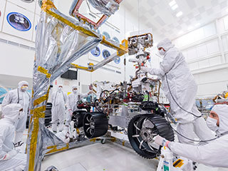 In this image, taken on June 13, 2019, engineers at JPL install the starboard legs and wheels — otherwise known as the mobility suspension — on the Mars 2020 rover.
