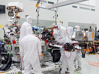 On June 21, 2019, engineers at NASA's Jet Propulsion Laboratory install the main robotic arm on the Mars 2020 rover. 