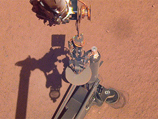 On June 28, 2019, NASA's InSight lander used its robotic arm to move the support structure for its digging instrument, informally called the "mole." This view was captured by the Instrument Deployment Camera on the spacecraft's robotic arm.