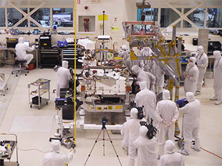 A team of engineers at NASA's Jet Propulsion Laboratory in Pasadena, California, install the legs and wheels — otherwise known as the mobility suspension — on the Mars 2020 rover. 