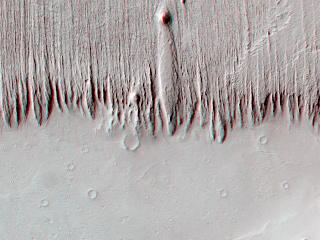 The material in the upper portion of this image, perhaps hardened volcanic ash deposits, is being eroded into parallel long, thin ridges called yardangs by the strong prevailing winds.