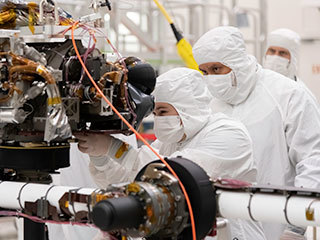 Engineers at JPL install a sensor-filled turret on the end of the rover's seven-foot-long (2.1-meter-long) robotic arm. The image was taken on July 11, 2019.