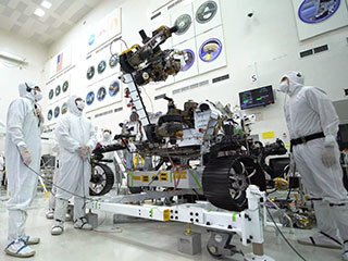 Photo taken in the clean room with the rover's 7-foot-long arm and its 88-pound sensor-laden turret as it moves from a deployed to a stowed configuration.