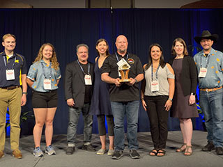 JPL engineer Glen Elliott (center) holds the 2019 Small Satellite Mission of the Year Award alongside others who supported the MarCO mission. Left to right: Matthew Szczerba, Kate Parkinson, Ben Malphrus, Kerri Cahoy, Glen Elliott, Chloe Hart, Emily Clements and John Belardo.