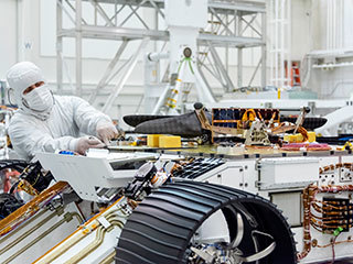 Engineers attached NASA's Mars Helicopter to the belly of the Mars 2020 rover on Aug. 27, 2019, at the Jet Propulsion Laboratory in Pasadena, California.