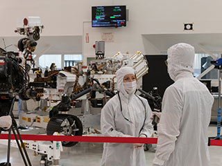 A member of the media interviews mission team member Jessica Samuels inside JPL’s High Bay 1 clean room on Dec. 27, 2019, during Mars 2020 media day.