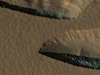 There are steep scarps facing the poles of both hemispheres that expose thick (up to 100 meters or more) sections of nearly pure water ice.