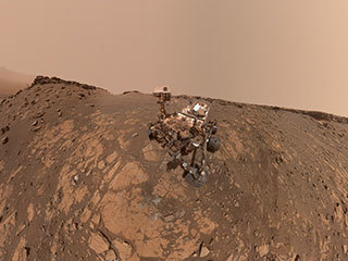 This selfie was taken by NASA's Curiosity Mars rover on Feb. 26, 2020. The crumbling rock layer at the top of the image is the Greenheugh Pediment, which Curiosity climbed soon after taking the image.
