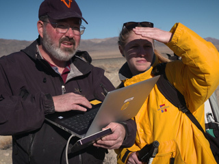 Two JPL scientists in a dry lakebed in the Nevada desert
