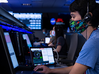 Mars 2020 mission engineer wearing a dinosaur mask during operations.