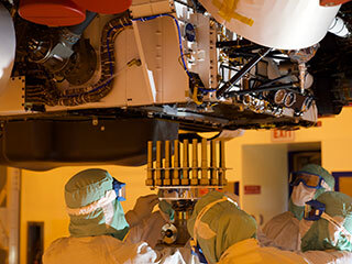 A tray holding 39 sample tubes – each protected in a gold-colored sheath – is installed in NASA's Perseverance rover in this picture taken at the agency's Kennedy Space Center on May 21, 2020.