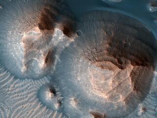 This image acquired on October 1, 2020 by NASAs Mars Reconnaissance Orbiter, shows several craters in Arabia Terra filled with layered rock.