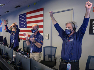 Members of NASA’s Perseverance rover team react as they hear Perseverance is safe on the ground
