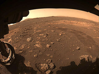 This image was captured while NASA’s Perseverance rover drove on Mars for the first time on March 4, 2021. One of Perseverance’s Hazard Avoidance Cameras (Hazcams) captured this image as the rover completed a short traverse and turn from its landing site in Jezero Crater.
