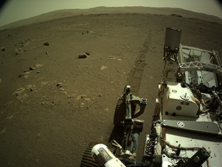 Image taken by Perseverance after driving with rover tracks behind it. 