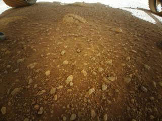 The Ingenuity Mars Helicopter took this image with its color camera from beneath the Perseverance rover after the rover had deployed the rotorcraft to the surface of Mars. Image was taken on April 3, 2021. 