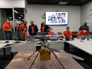 Members of NASA’s Ingenuity helicopter team react to data showing that the helicopter completed its first flight