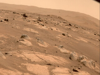 NASA’s Ingenuity Mars Helicopter (above center to the right) is viewed by one of the hazard cameras aboard the Perseverance rover during the helicopter’s fourth flight on April 30, 2021.