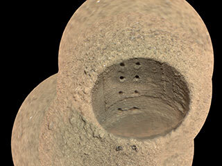 This composite image, made from four taken by the SuperCam instrument aboard NASA’s Perseverance rover on Aug. 8, 2021, shows the hole in a Martian rock where the rover attempted to collect its first sample; the small pits within it were created by laser zaps from SuperCam. 
