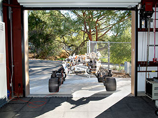 OPTIMISM faces a doorway of JPL’s Mars Yard garage shortly after arriving there on Oct. 29, 2021.