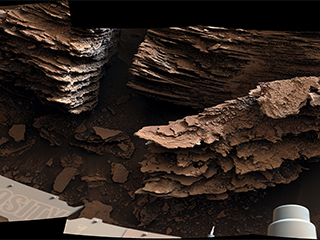 NASA’s Curiosity Mars rover captured this view of layered, flaky rocks believed to have formed in an ancient streambed or small pond – the six images that make up this mosaic were captured using Curiosity’s Mast Camera, or Mastcam, on June 2, 2022, the 3,492nd Martian day, or sol, of the mission.
