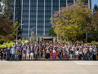 Members of the Perseverance rover Science Team pose in front of building at NASA's Jet Propulsion Laboratory.