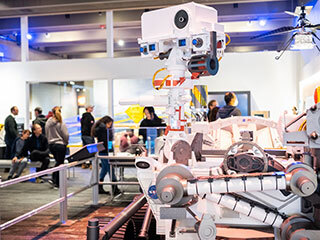 Members of the public interact with life-size models of the Perseverance rover and Ingenuity Mars helicopter during an exhibit at the Museum of Science in Boston, as part of the Roving With Perseverance road show.