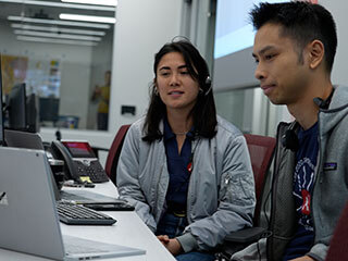 Image inside the control room with two Mars team members interacting virtually with student honorees.