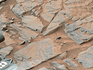 NASA’s Curiosity rover captured this image of rhythmic rock layers with a repetitive pattern in their spacing and thickness. 