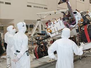 NASA's next Mars rover, Curiosity, stretches its robotic arm upward during Sept. 3, 2010, tests on a tilt table in a clean room at NASA's Jet Propulsion Labotatory, Pasadena, Calif. Test operators in clean room garb monitor the motions simulating maneuvers that the rover might make while on a sloped surface on Mars.
