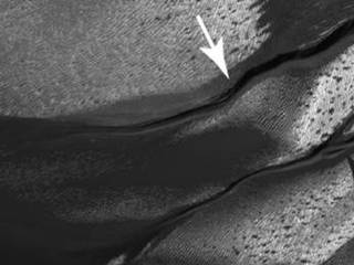 The gullies on a Martian sand dune in this trio of images from NASA's Mars Reconnaissance Orbiter deceptively resemble features on Earth that are carved by streams of water.