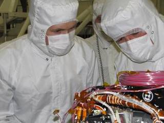 Grad student Nicholas Boyd (left) and Principal Investigator Ralf Gellert, both of the University of Guelph, Ontario, Canada, prepare for the installation of the Alpha Particle X-ray Spectrometer sensor head during testing at NASA's Jet Propulsion Laboratory.