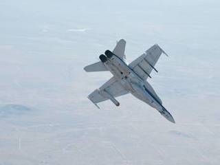 A NASA Dryden Flight Research Center F/A-18 852 aircraft performs a roll during a dive toward Rogers Dry Lake at Edwards Air Force Base, Calif., during June 2011 flight tests of a Mars landing radar.