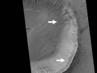 This image contrasts gullies and recurring warm-season slope flows appearing in the same crater, in the middle southern latitudes of Mars.